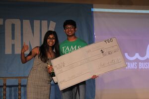 a student holding the winning prize for Shark Tank 2019
